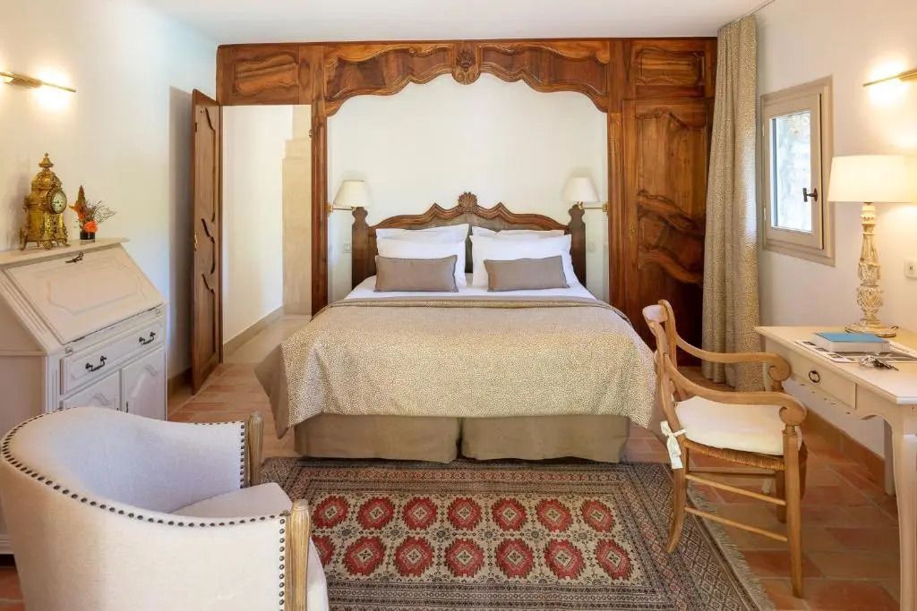 Elegantes Zimmer mit Doppelbett und kunstvollem Holzdekor an der Wand