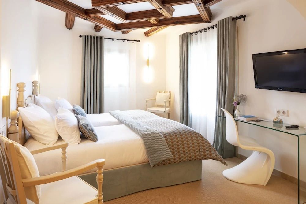 Lichtdurchflutetes Zimmer mit modernem Design und Holzbalkendecke im Hotel