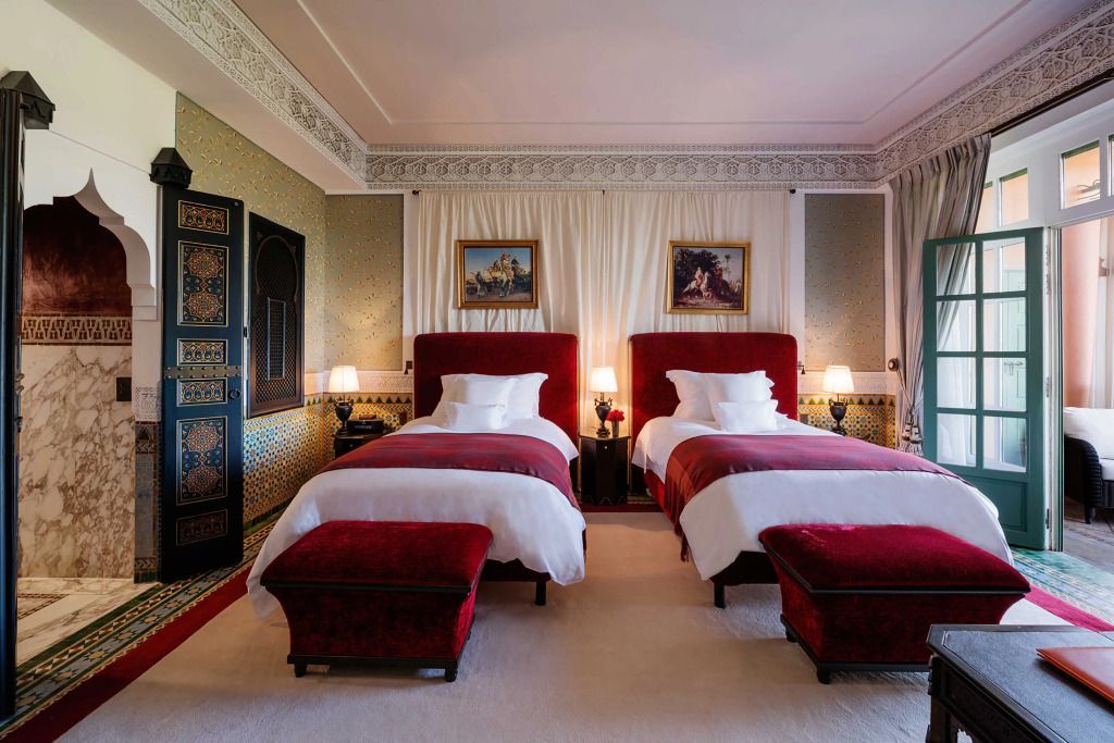Doppelzimmer der Al Mamoun Suite mit roten Samtbetten und kunstvollen Verzierungen.