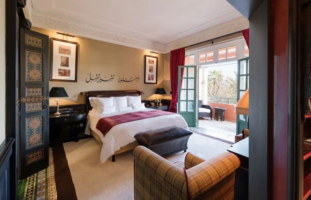 Luxuriöses Schlafzimmer in warmen Tönen mit Zugang zu einem privaten Balkon.