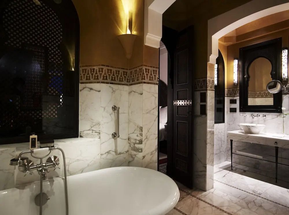 Elegantes Badezimmer mit Marmorfliesen und stilvoller Beleuchtung.