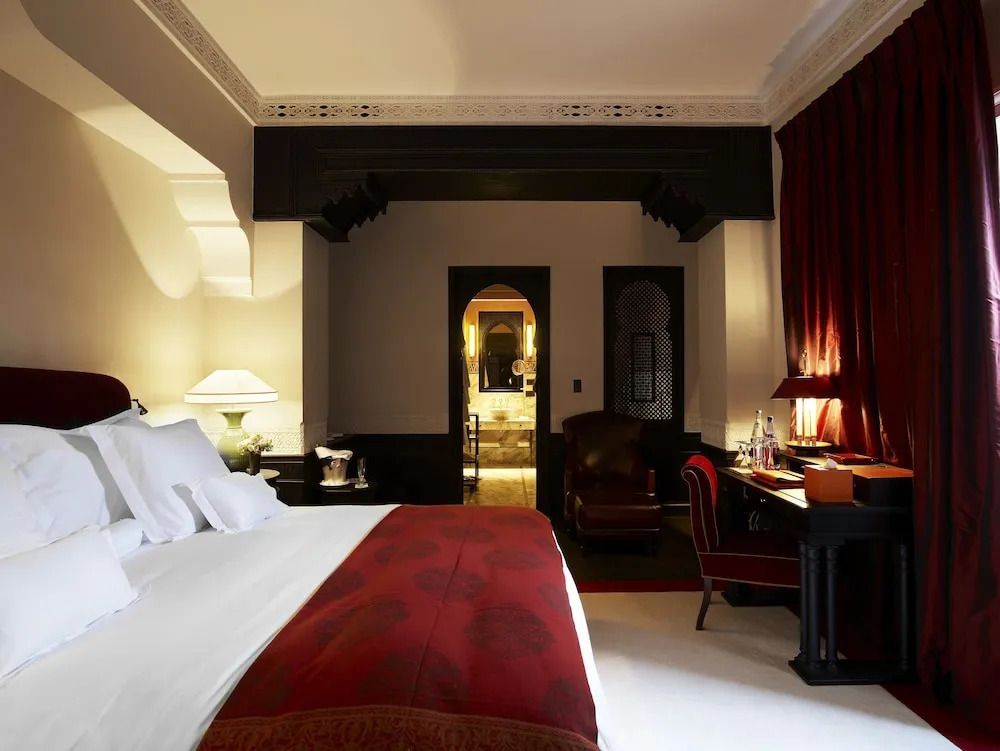 Elegantes Schlafzimmer der Hivernage Suite mit roten Akzenten und luxuriöser Einrichtung