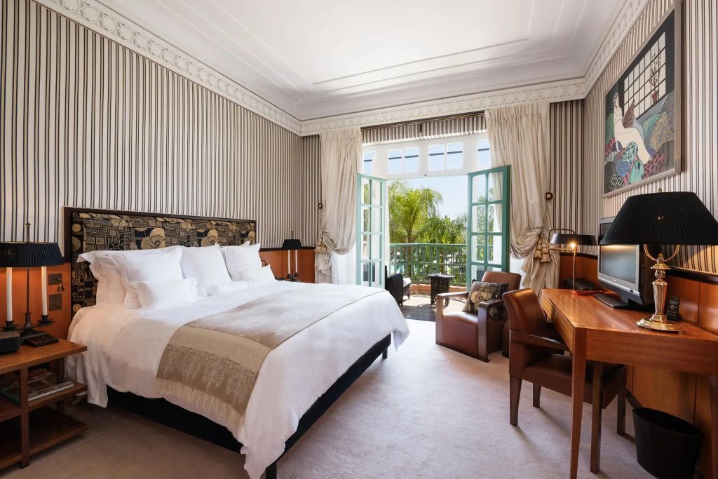 Luxuriöse Marquetry Suite mit elegantem Doppelbett und Balkon mit Blick auf den Garten
