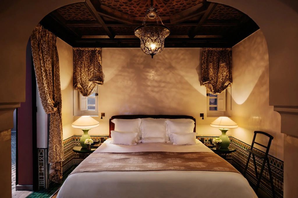 Luxuriöses Schlafzimmer im Riad mit prächtigem Kronleuchter und edlen Vorhängen