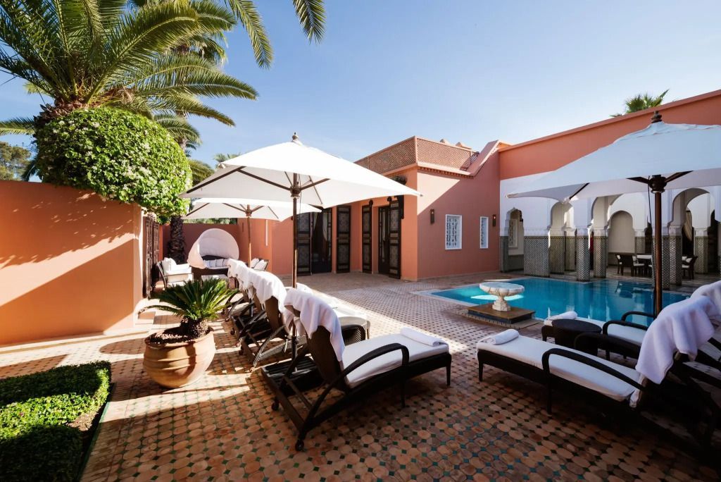 Sonnenterrasse eines Riads mit Pool und Sonnenliegen im mediterranen Ambiente