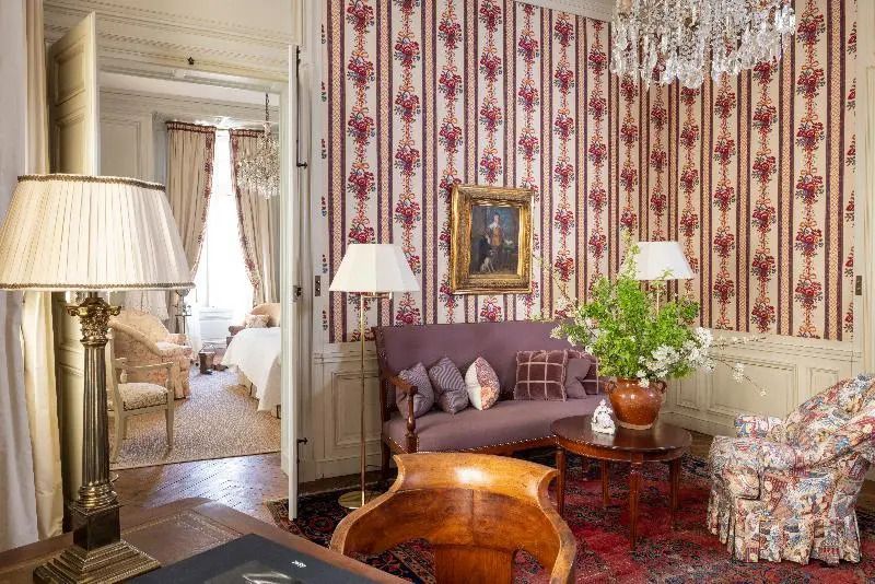Elegantes Wohnzimmer der Deluxe Suite mit kunstvollen Tapeten und Gemälden
