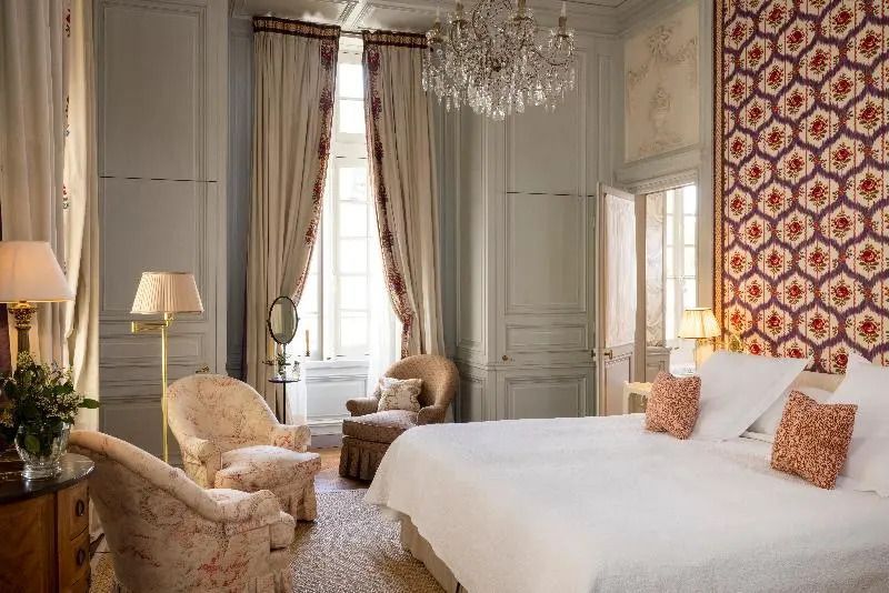 Schlafzimmer der Deluxe Suite mit luxuriösem Bett und edlen Vorhängen