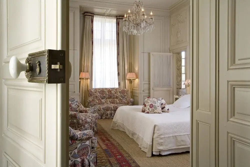 Luxuriöses Schlafzimmer mit Doppelbett, Kronleuchter und eleganten Stoffen