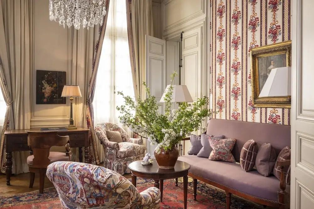 Komfortables Wohnzimmer mit Sofa, Sessel und großen Fenstern