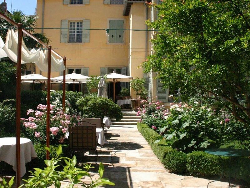 Charmanter Garten mit blühenden Pflanzen und Terrassensitzplätzen im Hotel La Mirande.