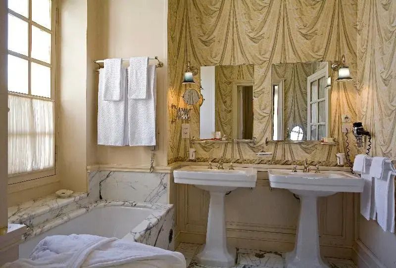 Elegantes Badezimmer mit Marmor und klassischen Armaturen.