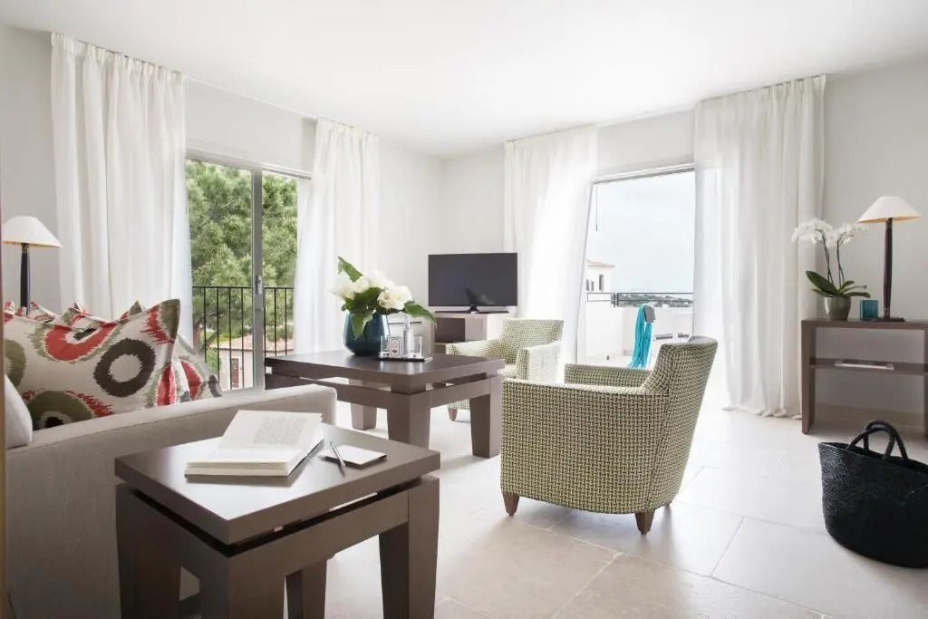 Helles Wohnzimmer mit stilvollen Möbeln und umlaufenden Fenstern