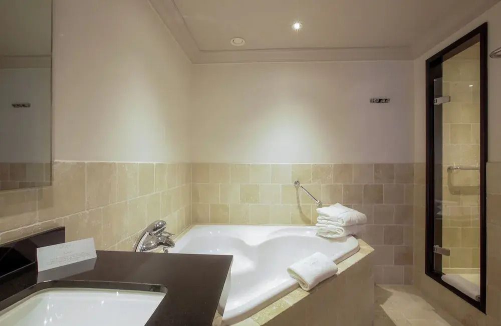 Geräumiges Badezimmer mit Badewanne und gefalteten Handtüchern