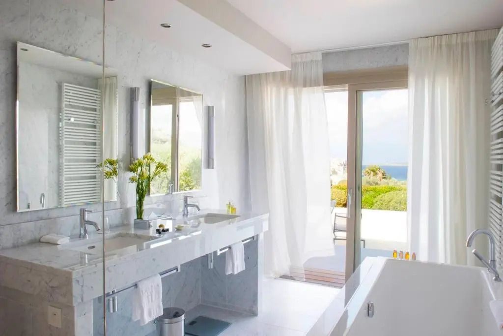 Luxuriöses Badezimmer mit Doppelwaschbecken und Badewanne mit Ausblick