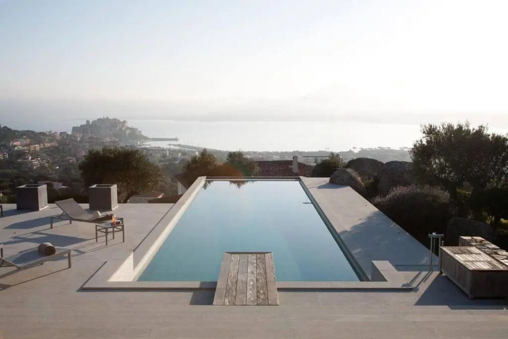 Infinity-Pool mit Meerblick und unberührter Landschaft im Hintergrund.