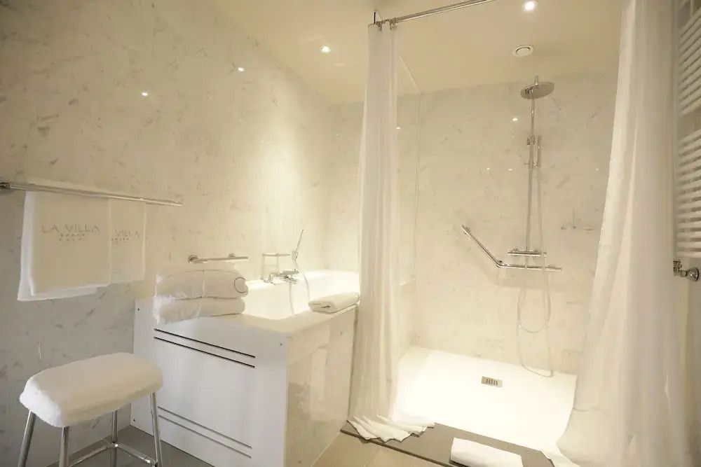 Elegantes Badezimmer mit Marmorfliesen und moderner Dusche im Hotel La Villa Calvi.