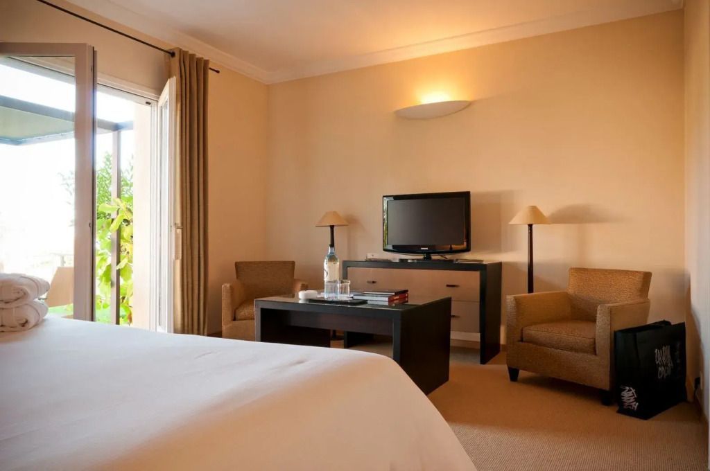 Gemütliches Wohnzimmer mit Sofas, Tisch und Fernseher in der Vierer Suite mit Balkon