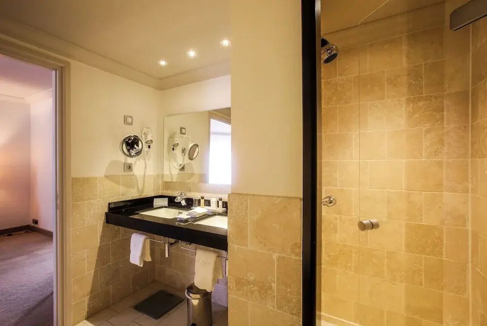 Elegantes Badezimmer mit Waschbecken und Dusche in der Vierer Suite des Hotels La Villa Calvi