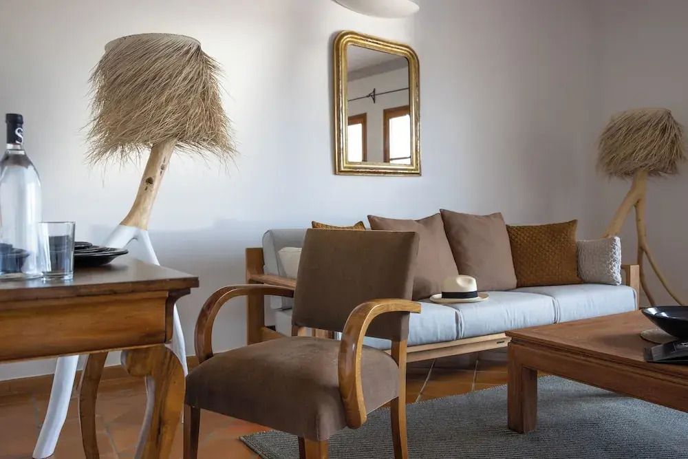 Geräumiger Wohnbereich mit Sessel und Couch in der Vierer Suite mit stilvoller Einrichtung