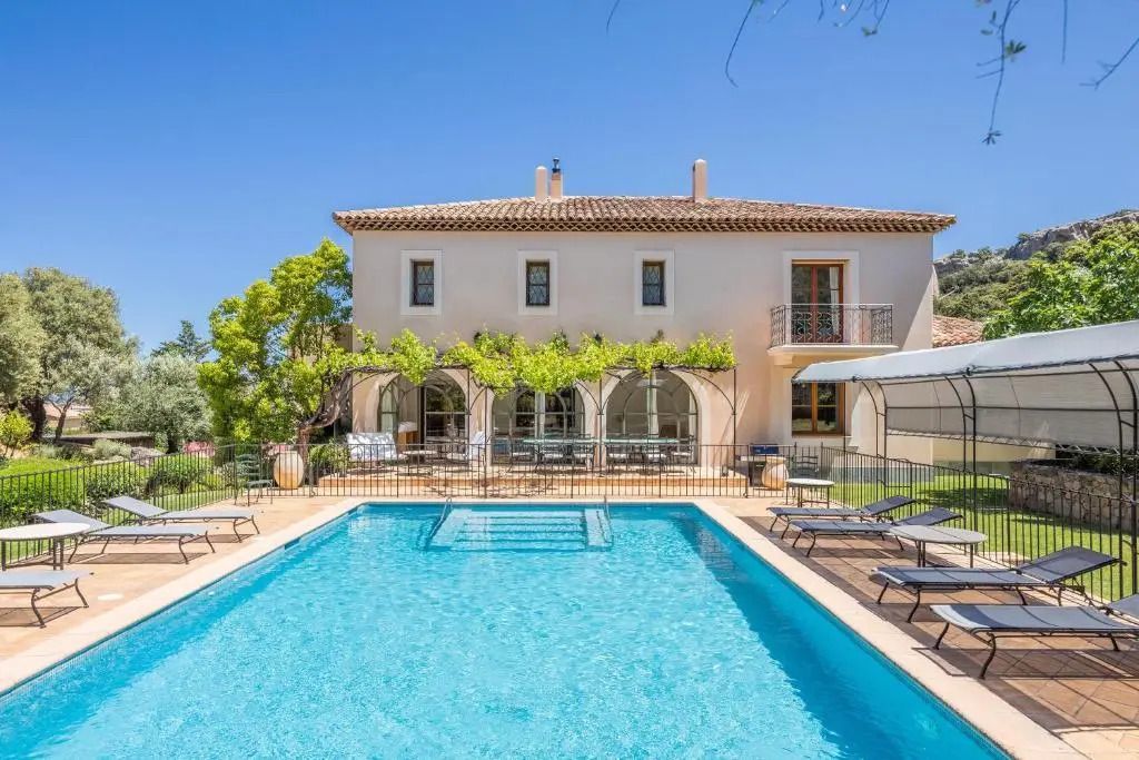 Außenansicht der Villa mit Pool und blühender Terrasse im Garten