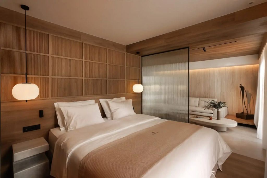 Helles Schlafzimmer mit Doppelbett und Holzdetails in einer Suite