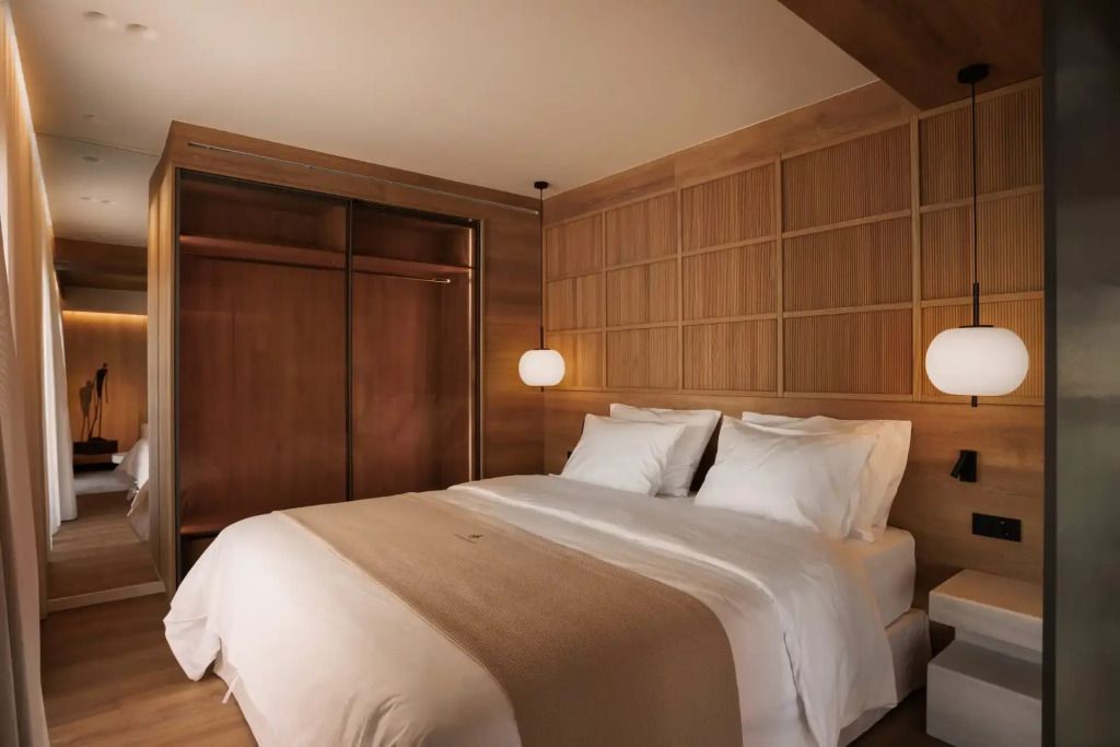 Elegant eingerichtetes Schlafzimmer mit Doppelbett und Holzverkleidung