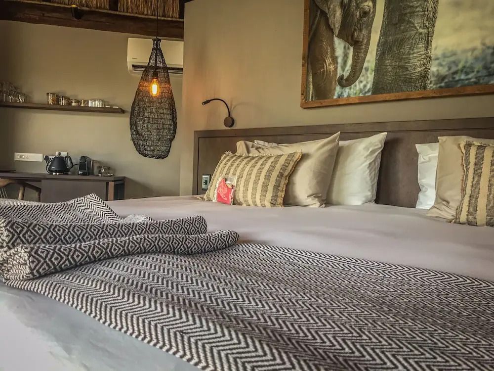 Komfortables Bett in Luxus Suite mit afrikanischer Deko und Kunst