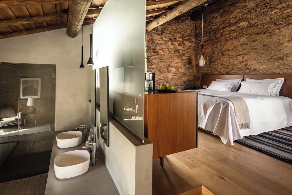 Elegantes Schlafzimmer und Bad mit rustikaler Wand in der Deluxe Suite