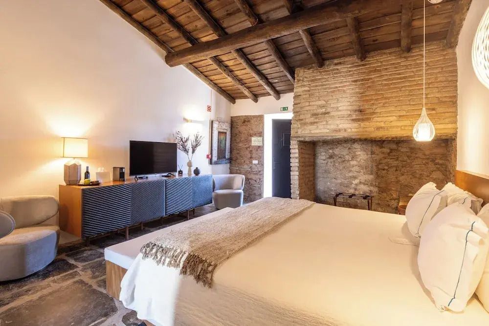 Gemütliches Schlafzimmer mit Holzbalkendecke und TV in der Junior-Suite