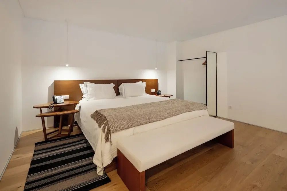 Geräumiges Schlafzimmer mit Doppelbett, Leuchten und Holzdetails.