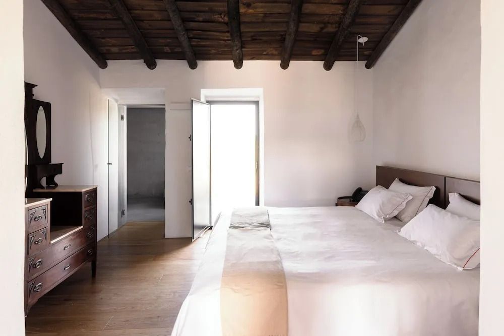 Helles Schlafzimmer der Superior Suite mit Holzbalkendecke.