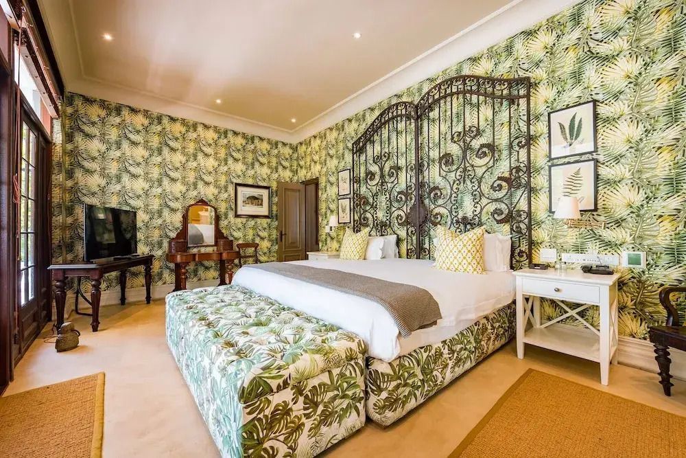 Elegant eingerichtetes Schlafzimmer mit floralen Tapeten und großem Doppelbett