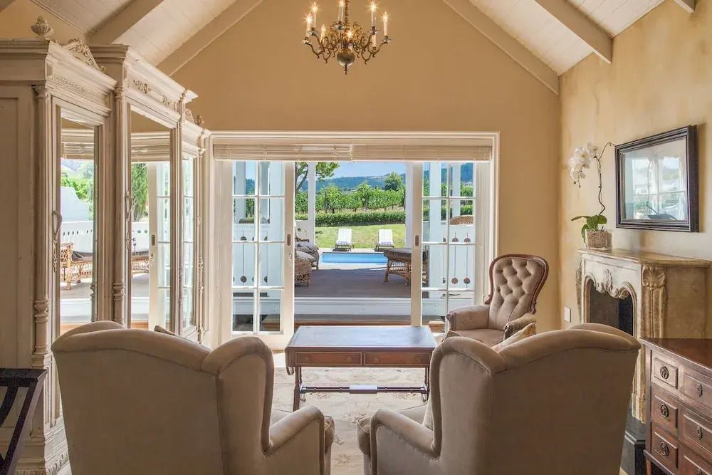 Geräumige Lounge mit Blick auf Pool und Garten durch hohe Fenster
