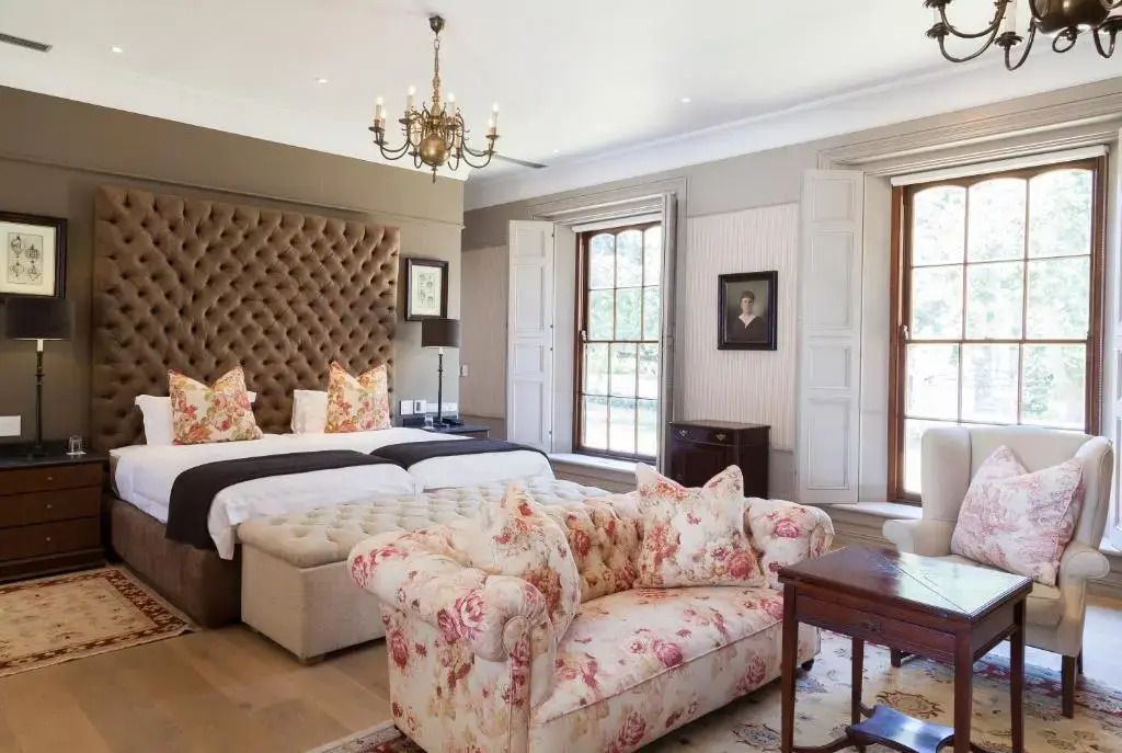 Junior-Suite mit eleganter Einrichtung, florales Sofa und luxuriöse Bettwäsche.