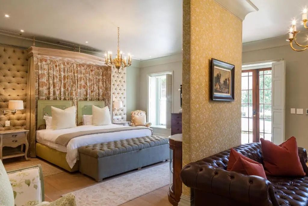 Gemütliche Junior-Suite mit elegantem Teppich, Sofa und Kronleuchter.