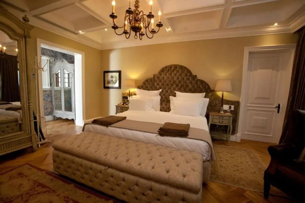 Elegantes klassisches Hotelzimmer mit Kronleuchter und gepolstertem Möbelstück