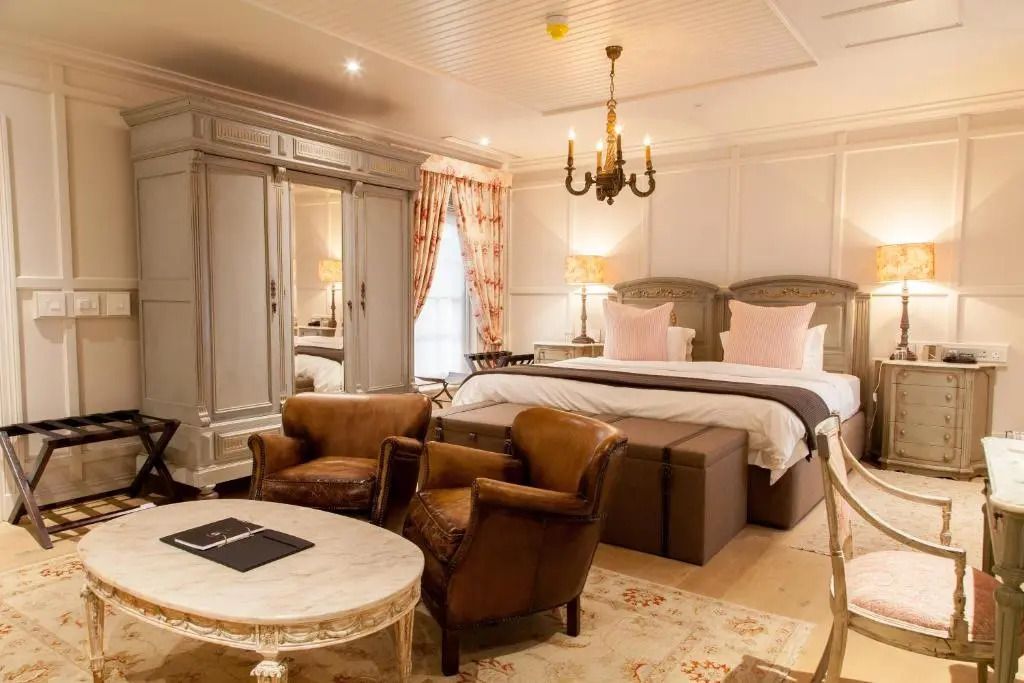 Stilvolles Hotelzimmer mit Vintage-Sesseln und großem Schrank