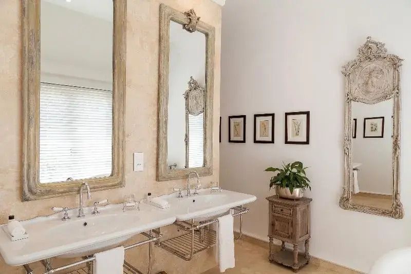 Badezimmer mit zwei Waschbecken und dekorativen Spiegeln