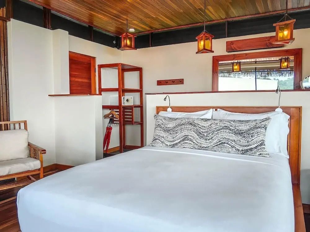 Gemütliches Schlafzimmer mit Holzakzenten und einem großen Bett in der Lapa Rios Lodge