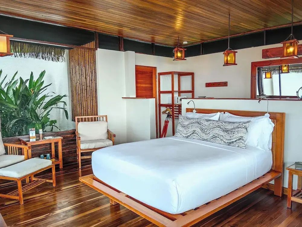 Geräumiges Schlafzimmer mit Holzdekor und Blick auf Natur in der Lapa Rios Lodge
