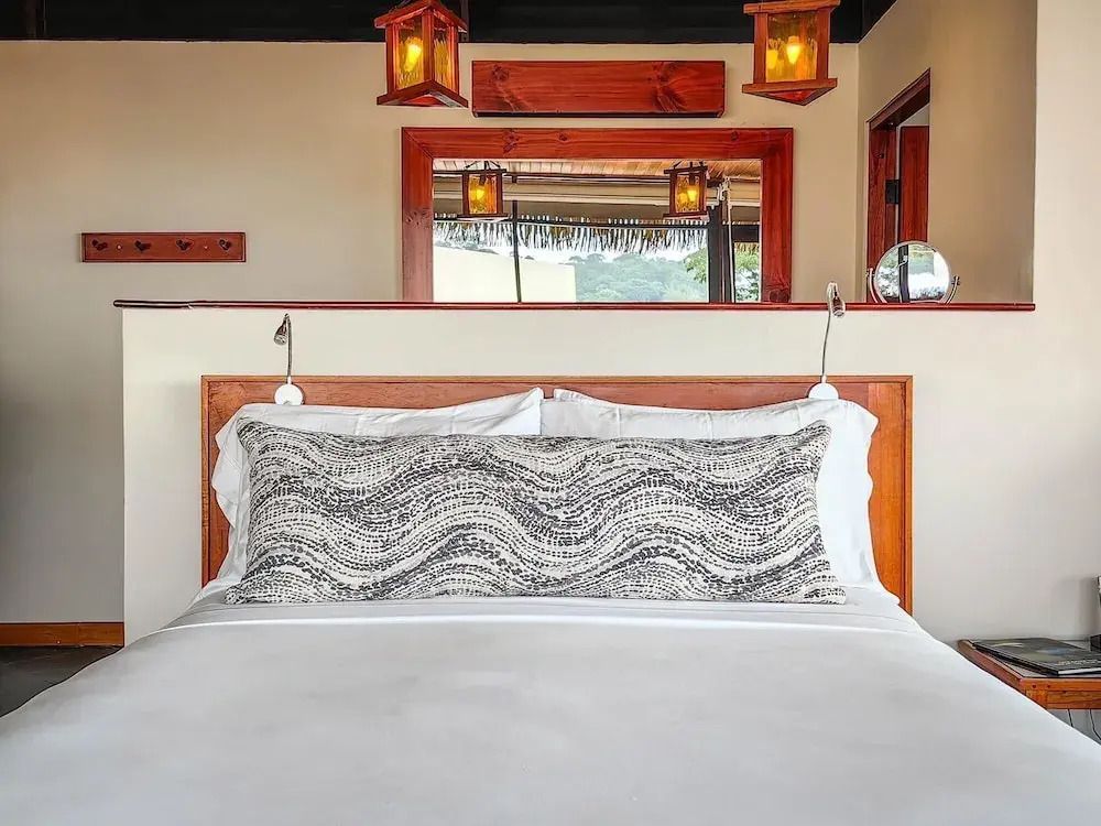 Modernes Bett mit dekorativem Kissen in der Lapa Rios Lodge