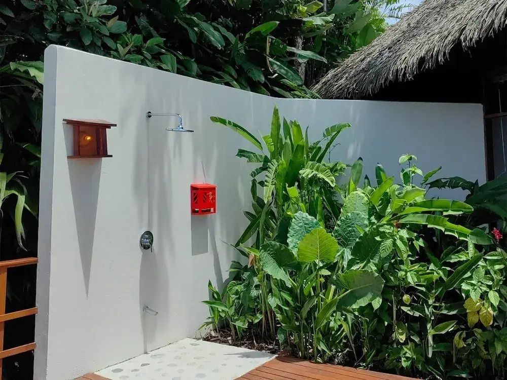 Private Außendusche mit tropischen Pflanzen und modernem Design