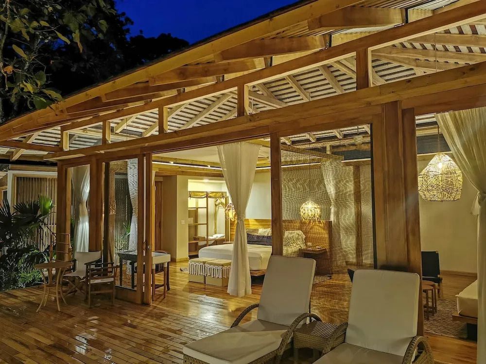 Villen-Außenansicht mit Holzveranda und gemütlichem Innenraum bei Nacht