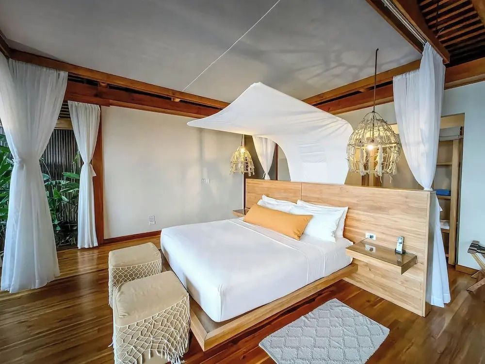Elegantes Schlafzimmer mit Baldachin-Bett und Holzdielen in der Lapa Rios Lodge