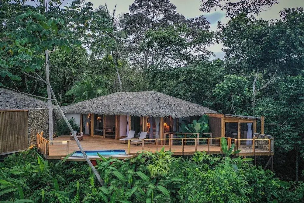 Außenansicht einer Villa mit Pool inmitten tropischer Vegetation