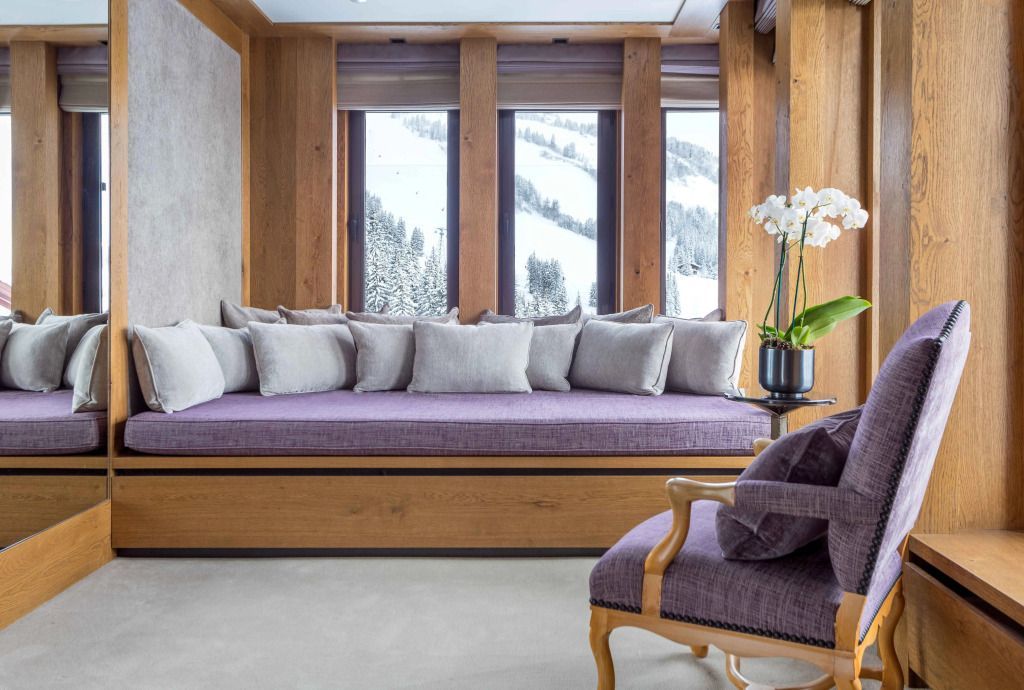 Gemütliches Zimmer im Aman Le Mélézin mit großen Fenstern und Alpenblick