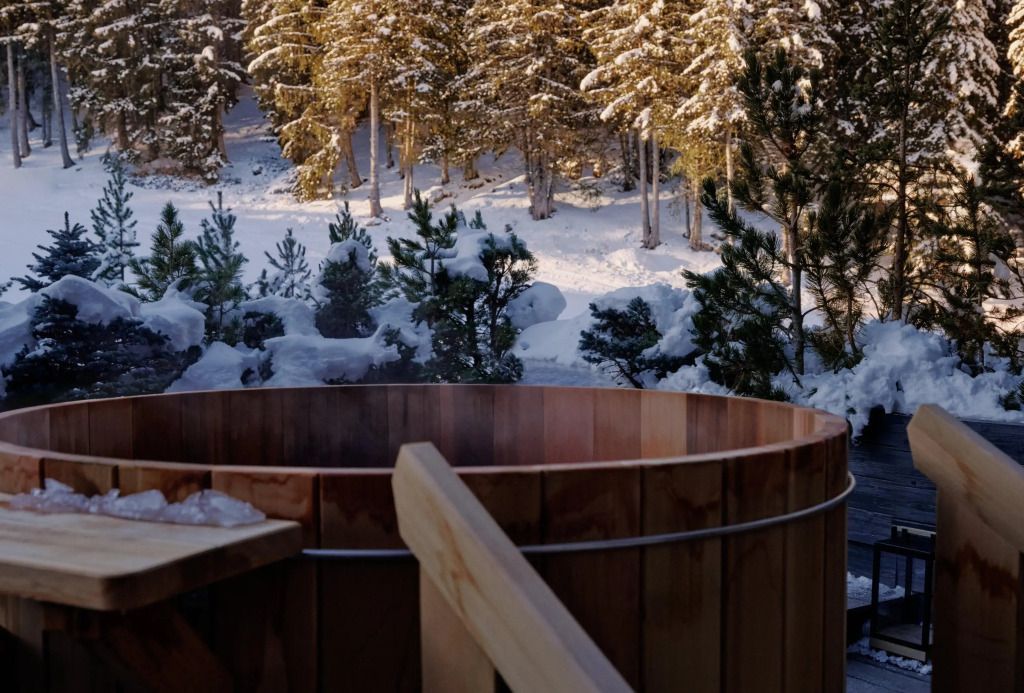 Holzaußenwanne im verschneiten Wald beim Aman Le Mélézin