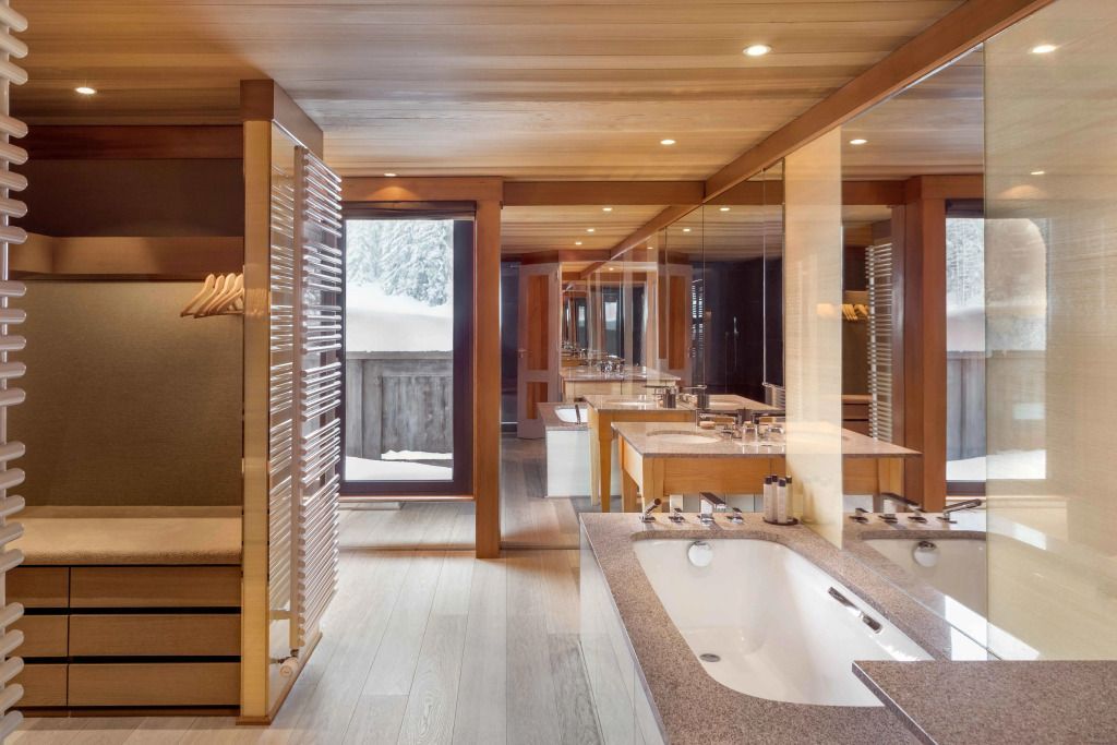 Luxuriöses Badezimmer mit Badewanne und großer Spiegelfront in einer Suite