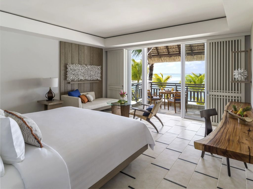 Helles Schlafzimmer mit Balkon und Meerblick in der Coral Suite