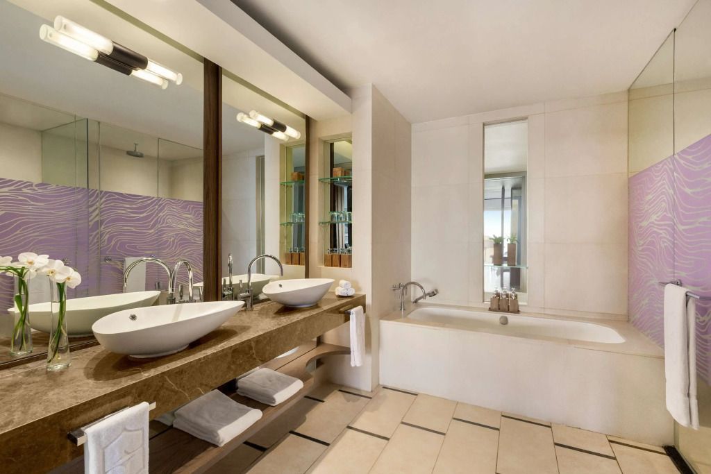 Luxuriöses Badezimmer mit Doppelwaschbecken und Badewanne in der Coral Suite